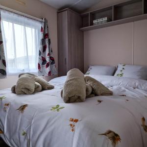 米德尔克尔克Caravan Aan Zee Arnani的卧室里放着两只填充的动物躺在床上