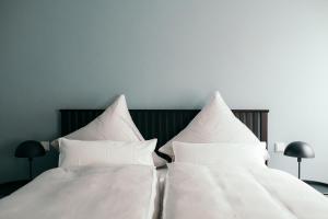 特里滕海姆Moselhaus by Clüsserath-Wittmann的卧室的床上配有2个白色枕头