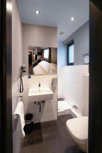 美因河畔法兰克福法兰克福卡尔特酒店的一间带水槽和卫生间的浴室以及一张床