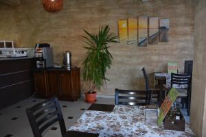 普里莫尔斯科Семеен Хотел Детелини的一间配备有桌椅和植物的餐厅