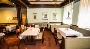 维也纳哈里甘酒店的一间设有白色桌椅的用餐室