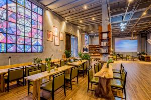 桂林桂林厂舍酒店的餐厅设有桌椅和彩色玻璃窗