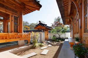 首尔IRIRU Luxury Hanok Stay - Eunpyung Hanok village的一座带木制建筑的庭院