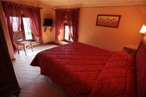 巴贝里诺·迪·穆杰罗普吉阿格里乌利伟酒店的一间在房间内配有红色床的卧室