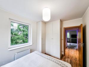 姆拉哥沃Apartament VIP PROMENADA的卧室配有白色的床和窗户。