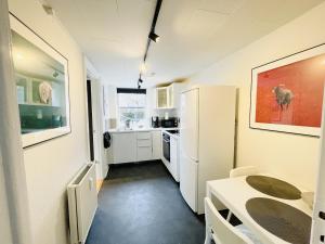 奥尔堡aday - Charming Studio close to the Football Stadium的厨房配有桌子和白色冰箱。