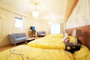 大阪MATATABI STAY Daikokucho的一间卧室配有两张床、一张沙发和一把椅子