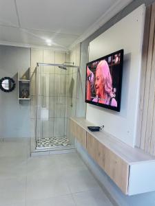 察嫩Executive Galaxy Guest House Nkowankowa Extension 2的一间带淋浴的浴室,墙上配有电视