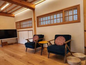 首尔IRIRU Luxury Hanok Stay - Eunpyung Hanok village的客厅配有2把椅子和平面电视