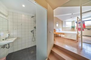 斯普利特Design Hostel One的带淋浴的浴室和客房内的一张床
