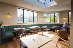 LlanrhystydPenrhos Park的餐厅设有桌椅和窗户。
