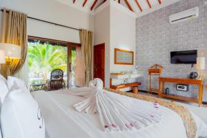 博拉科特Bintan Exotica Resort的卧室配有白色床,其翼面铺满