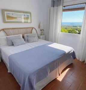 埃斯·梅卡达尔La Terraza de la Sabina的一间卧室设有一张大床和大窗户