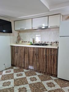 巴库тихий дворик的厨房配有木制橱柜和白色冰箱。