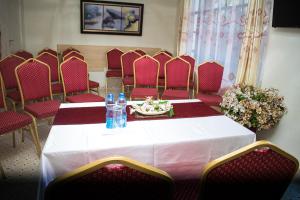 KaratinaTHE PLANTAINS PLACE的一间会议室,配有桌子和红色椅子