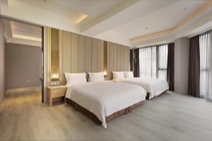 礁溪Gamalan Star Hotel的酒店客房设有两张床和大窗户。