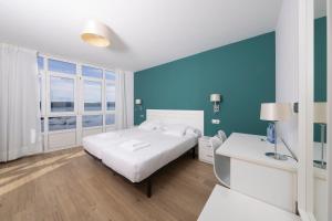 菲尼斯特雷玛德福斯特拉酒店的卧室配有白色的床和蓝色的墙壁
