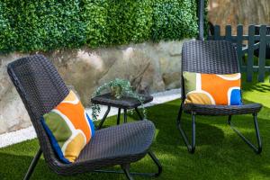 波尔图Pestana Apartments - Premium的两把椅子和枕头坐在草地上