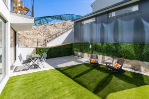 波尔图Pestana Apartments - Premium的后院设有草坪、椅子和桌子
