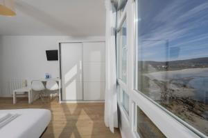 菲尼斯特雷玛德福斯特拉酒店的卧室设有海景大窗户