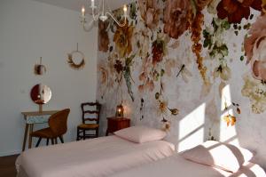 Saint-Pierre-de-CurtilleJ&G House的一间卧室设有一张床和花墙