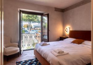 梅纳焦Leoni 7的卧室配有床、椅子和窗户。