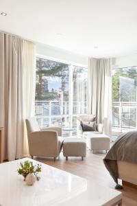 灵达尔罗斯峡湾斯特朗酒店的客厅配有白色家具和大窗户