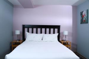 姆巴巴内Sibebe View Villa的一间卧室配有白色床和2个床头柜