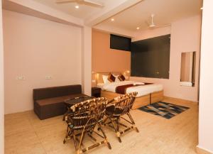 达兰萨拉Hotel Buddha's Abode的卧室配有一张床和一张桌子及椅子