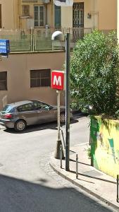 那不勒斯Chicco's Suite的汽车旁的路灯上的一个红色标志
