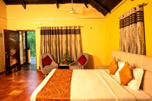 海得拉巴Farm Stay Resort - Shamirpet, Hyderabad的一间卧室配有一张带两把椅子的床和一扇窗户