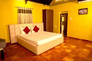 海得拉巴Farm Stay Resort - Shamirpet, Hyderabad的黄色客房内的一间卧室配有一张大床