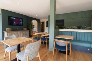 LlanrhystydPenrhos Park的餐厅设有木桌和蓝色椅子