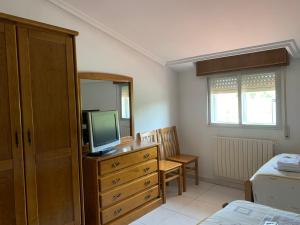 圣西普安－德比尼亚斯塞凯伊罗斯旅馆的一间卧室配有带电视和床的梳妆台。