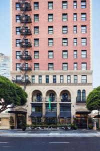 洛杉矶Hotel Figueroa, Unbound Collection by Hyatt的一座高大的红砖建筑,有火源