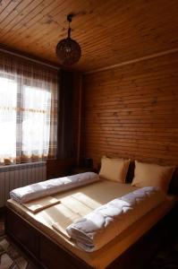 瑟尔尼察Ваканционно селище Ива的木墙客房内的一张大床