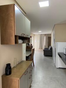 福塔莱萨ARCO IRIS KITNETS的一间带白色橱柜的厨房和一间客厅