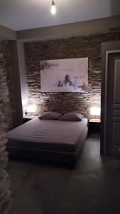 ApróvatonAegean Deep Blue Andros Ano Aprovato的一间卧室设有一张床和石墙