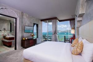 芭东海滩Patong Signature Boutique Hotel的一间带大床的卧室,享有海景