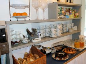 Gästehaus Brütting的装有杯子和盘子的书架,装有食物和饮料
