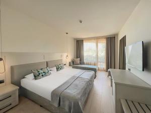 金沙GRIFID Moko Beach - 24 Hours Ultra All Inclusive & Private Beach的一间卧室配有一张大床和一张沙发