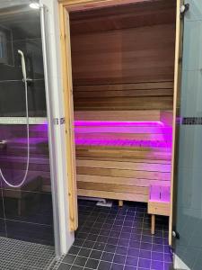 坦佩雷Stunning 5BR 16 Bed Home with Finnish Sauna & Jacuzzi 340 m2的浴室内带紫色照明的桑拿浴室