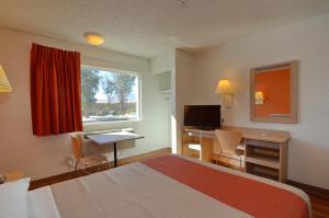 North Palm Springs棕榈泉北6号汽车旅馆的配有一张床、一张书桌和一扇窗户的酒店客房