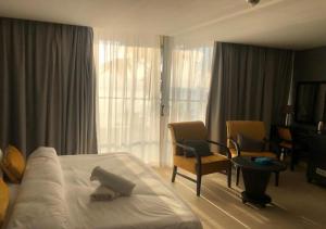 索瓦马O Beach Hotel & Resort的酒店客房,配有一张床和两把椅子