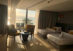 索瓦马O Beach Hotel & Resort的酒店客房,配有床和沙发