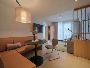 维也纳Adina Apartment Hotel Vienna Belvedere的客厅配有沙发和桌子