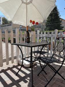 伦诺Cà del Fili的一张桌子、一把雨伞和一把带鲜花的椅子