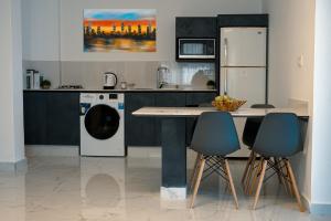 安曼Al Kawther Hotel Apartments的厨房配有冰箱和洗衣机。