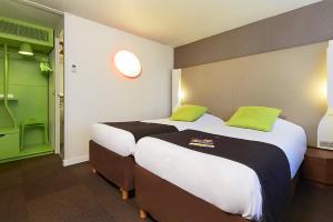 里摩日北里摩日钟楼酒店的酒店客房设有两张绿色床铺。