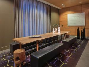 柏林柏林哈克市场阿迪娜公寓式酒店的一间带木桌和皮椅的用餐室